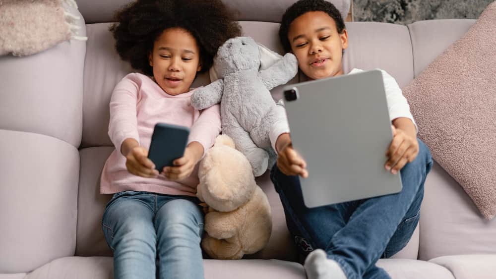 Parent and child sitting together on a couch setting screen time boundaries calmly