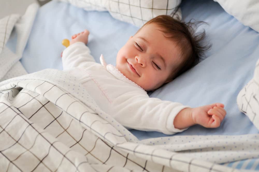 Baby sleeping peacefully while holding a soft teething toy