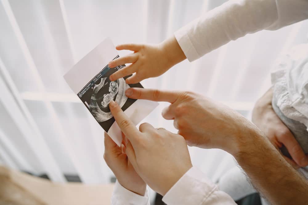 Pregnant couple discussing prenatal genetic screening results with a doctor