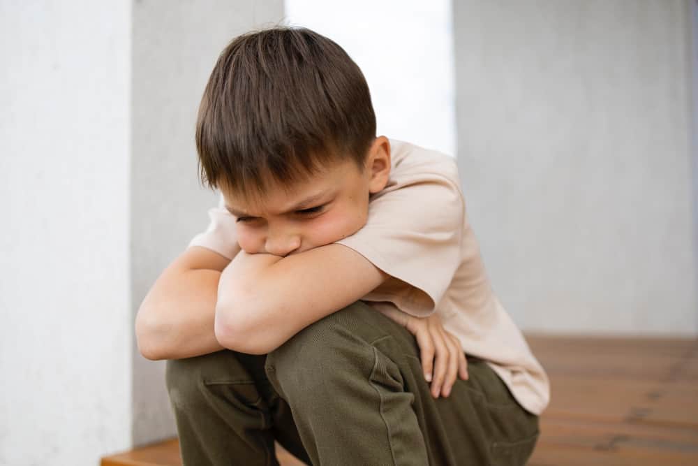 Parent sitting with a child and calmly talking about emotions using picture cards